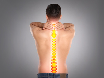 Image of Man suffering from pain in spine on light grey background