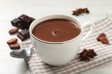 Photo of Yummy hot chocolate in cup on white wooden table