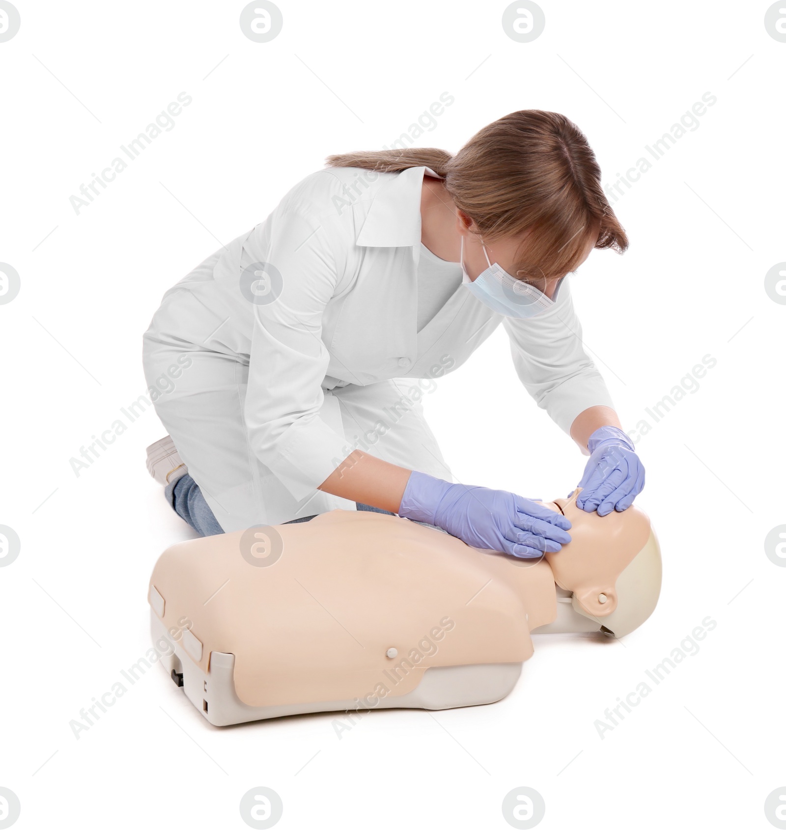 Photo of Doctor in uniform and protective mask practicing first aid on mannequin against white background