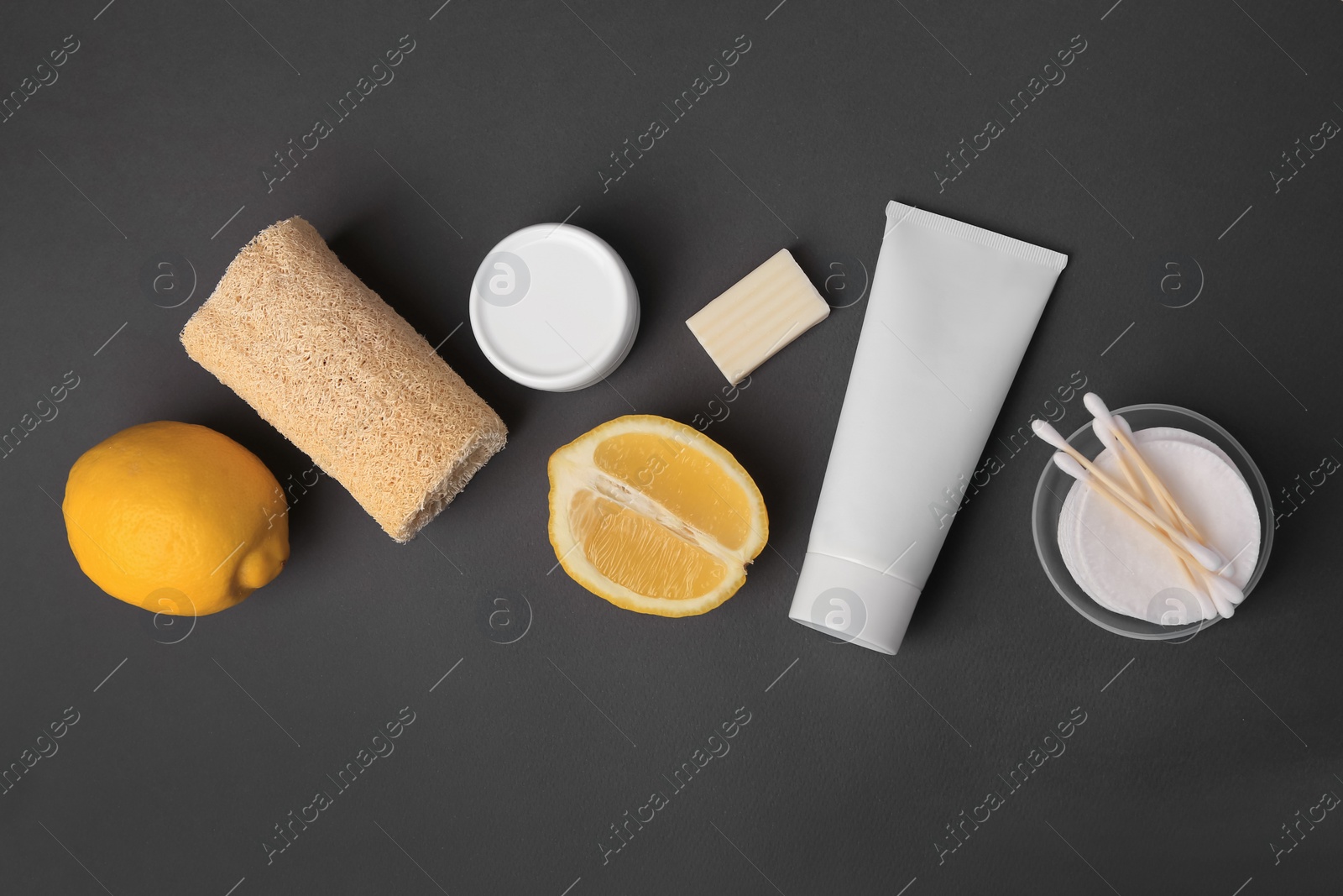 Photo of Lemon face wash. Fresh citrus fruits and personal care products on dark grey background, flat lay