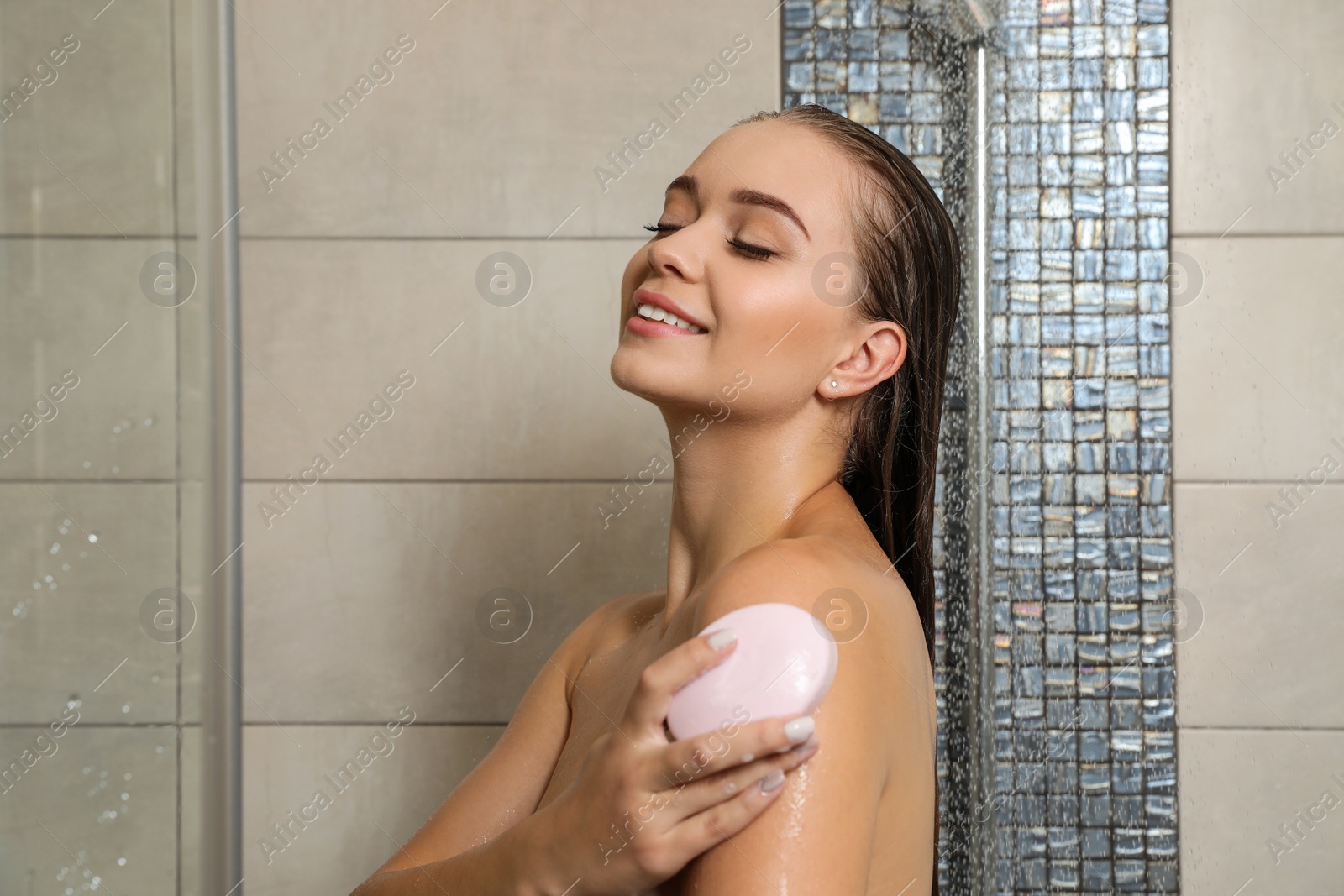 Photo of Beautiful young woman taking shower with soap in bathroom. Space for text