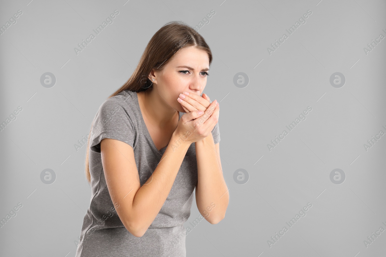 Photo of Woman suffering from nausea on grey background, space for text. Food poisoning