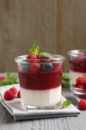 Photo of Delicious panna cotta with berries on grey wooden table