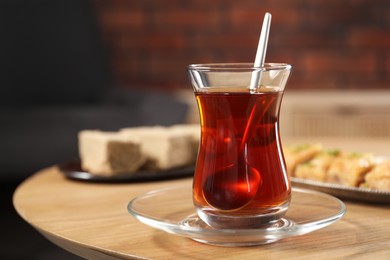 Traditional Turkish tea in glass on wooden table. Space for text