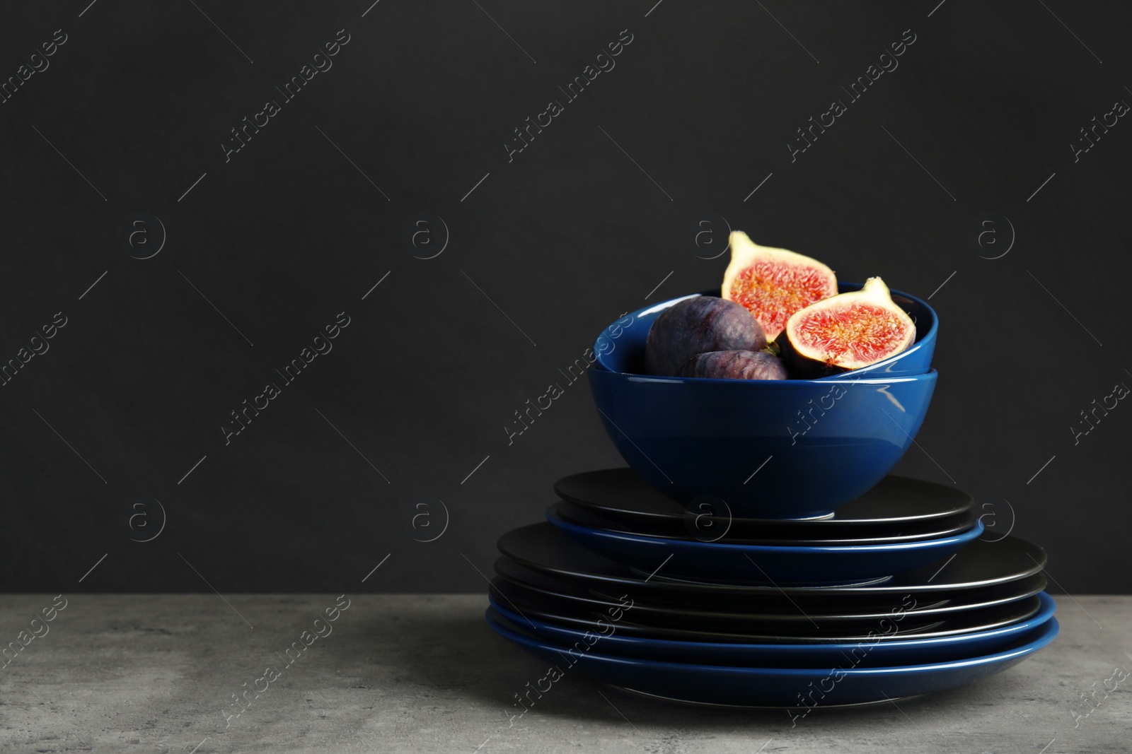 Photo of Composition with dinnerware on table against dark background, space for text. Interior element