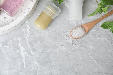 Photo of Flat lay composition with natural crystal alum deodorants and space for text on light grey marble table