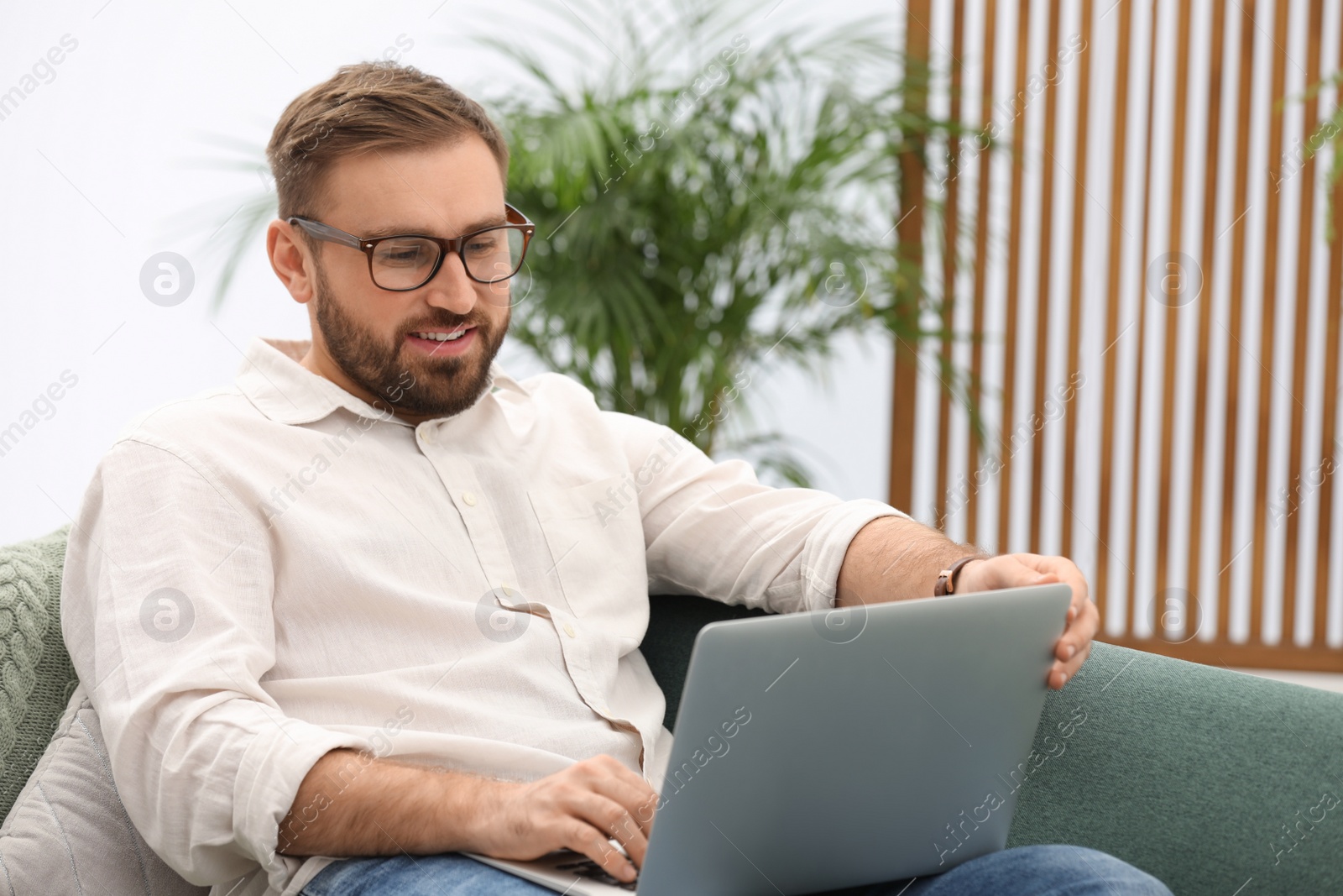 Photo of Young man working with laptop at home