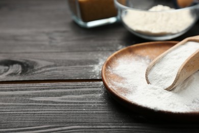 Pate and scoop with baking powder on black wooden table, closeup. Space for text