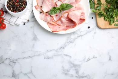 Photo of Flat lay composition with sliced raw bacon on white marble table. Space for text