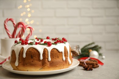 Photo of Traditional Christmas cake with cranberries, pomegranate seeds and rosemary on light grey table, space for text