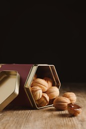 Homemade walnut shaped cookies with boiled condensed milk on wooden table, space for text