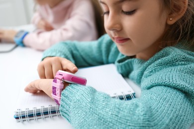 Girl with stylish smart watch at table, closeup