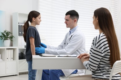 Photo of Gastroenterologist examining girl with stomach ache in clinic