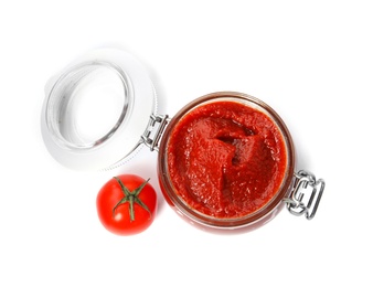 Photo of Tasty homemade tomato sauce in glass jar and fresh vegetable on white background, top view