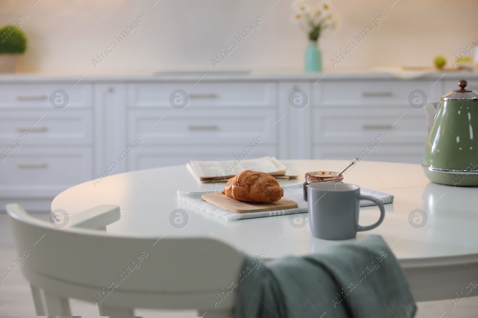 Photo of Delicious breakfast with fresh croissant and cup of hot drink in kitchen