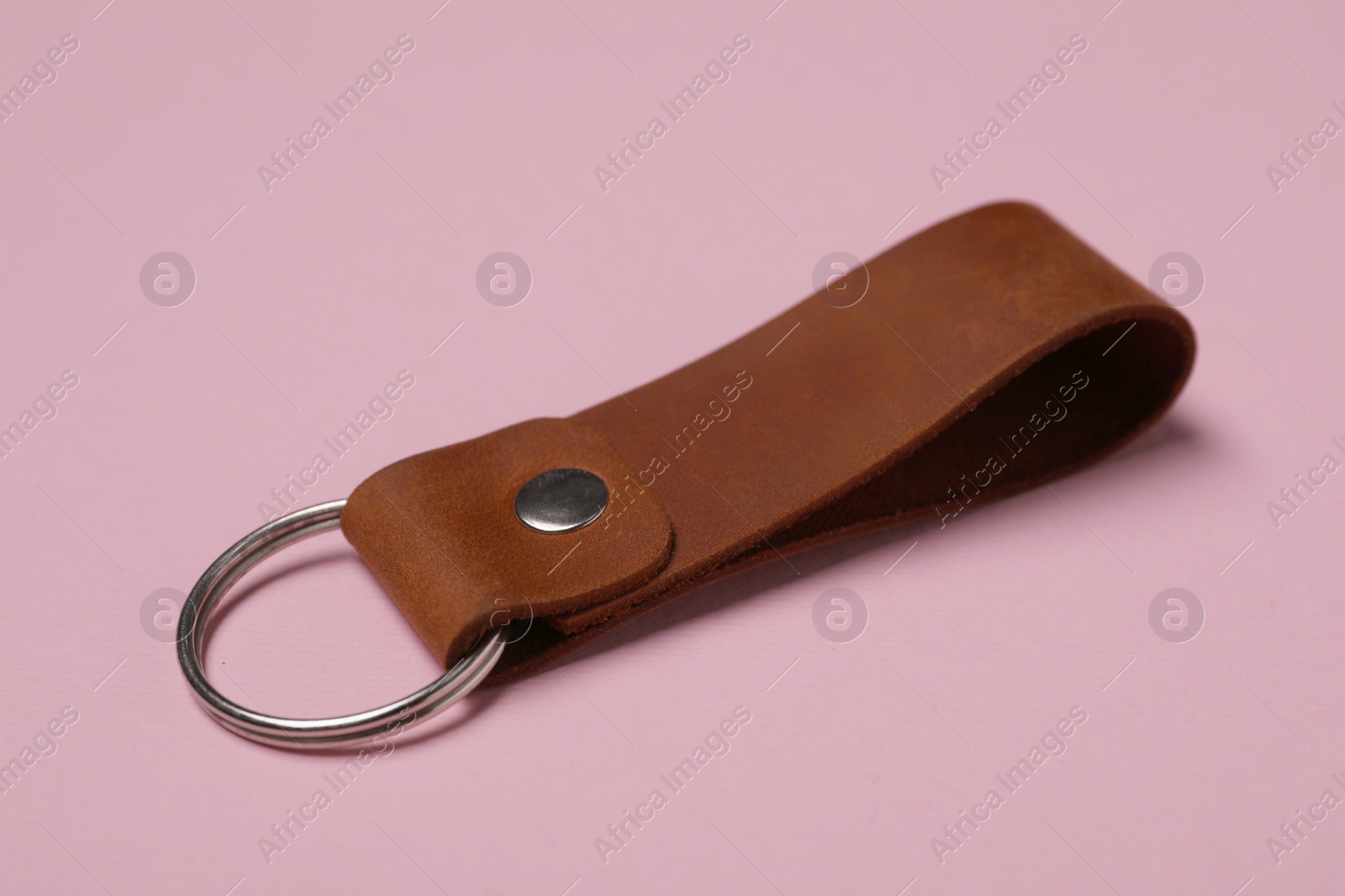 Photo of Leather keychain with Ukrainian coat of arms on pale pink background