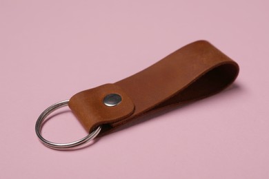 Leather keychain with Ukrainian coat of arms on pale pink background