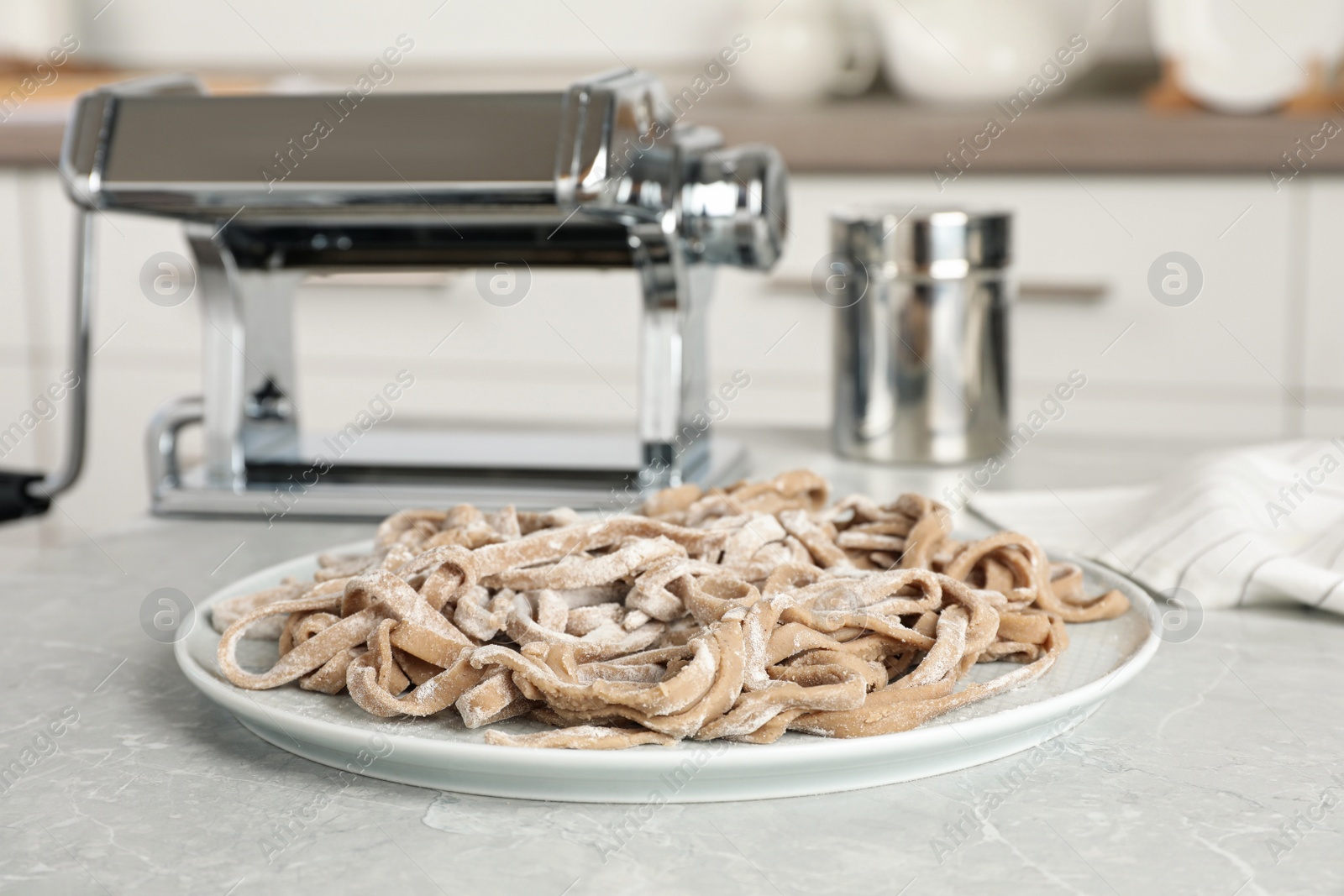 Photo of Uncooked homemade soba (buckwheat noodles) on grey table in kitchen