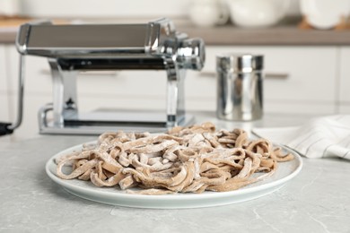 Uncooked homemade soba (buckwheat noodles) on grey table in kitchen