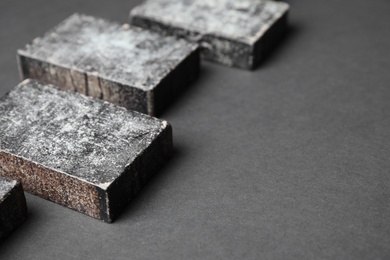 Photo of Natural tar soap on black table, closeup. Space for text