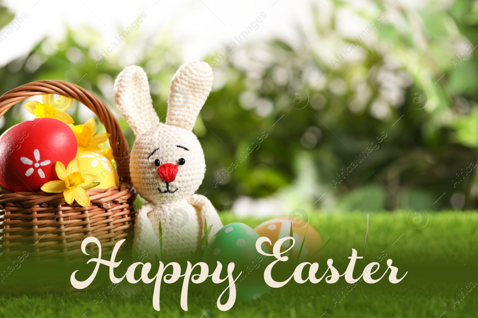 Image of Colorful eggs, toy rabbit on green grass with text Happy Easter