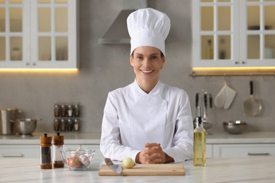 Portrait of professional chef near table with ingredients at kitchen