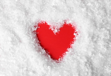 Photo of Heart shaped silhouette in decorative snow on color background, top view