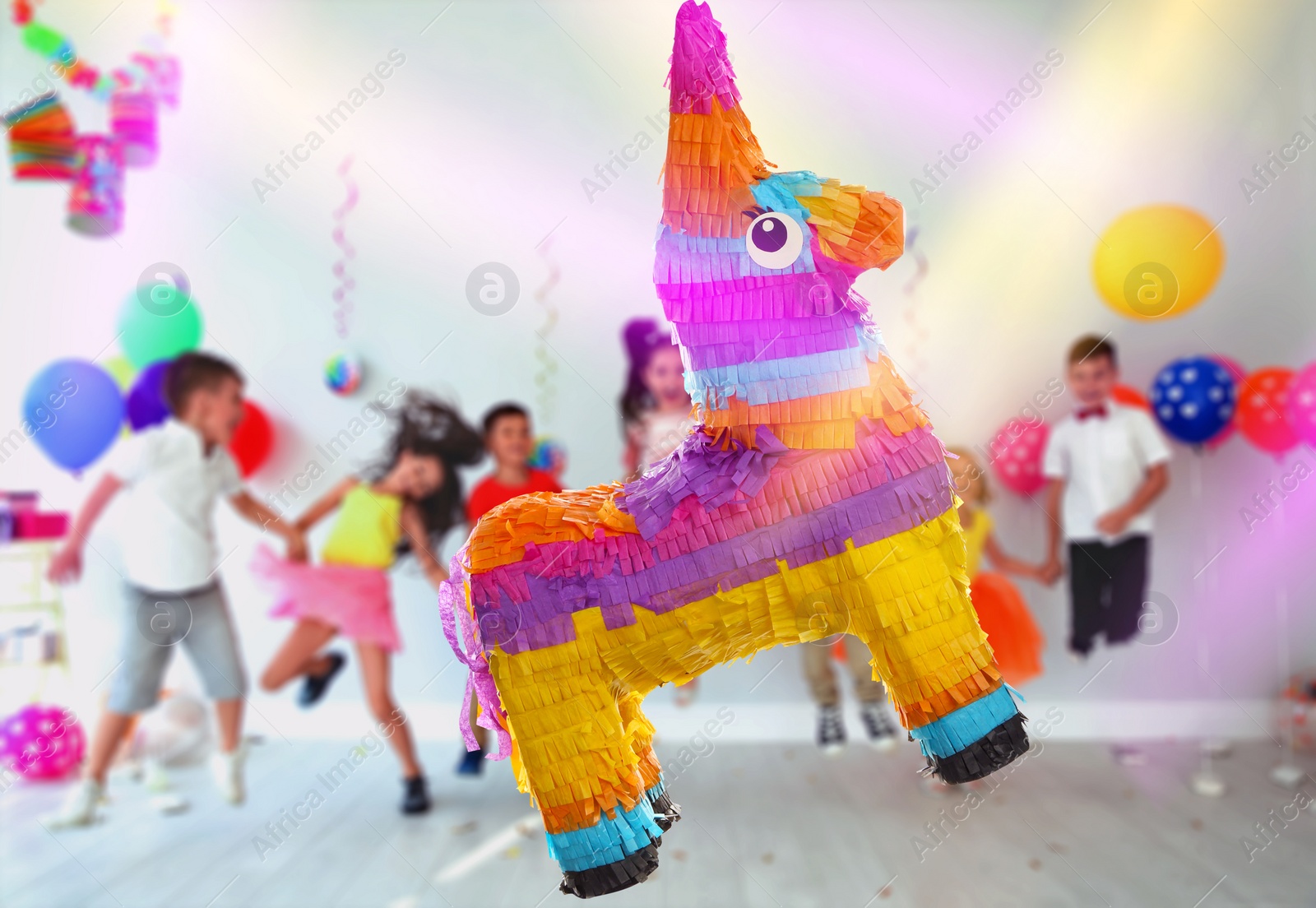 Image of Bright festive pinata hanging indoors at birthday party