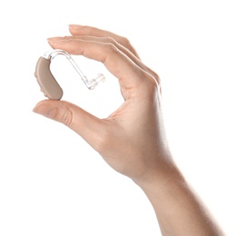 Photo of Woman holding hearing aid on white background, closeup
