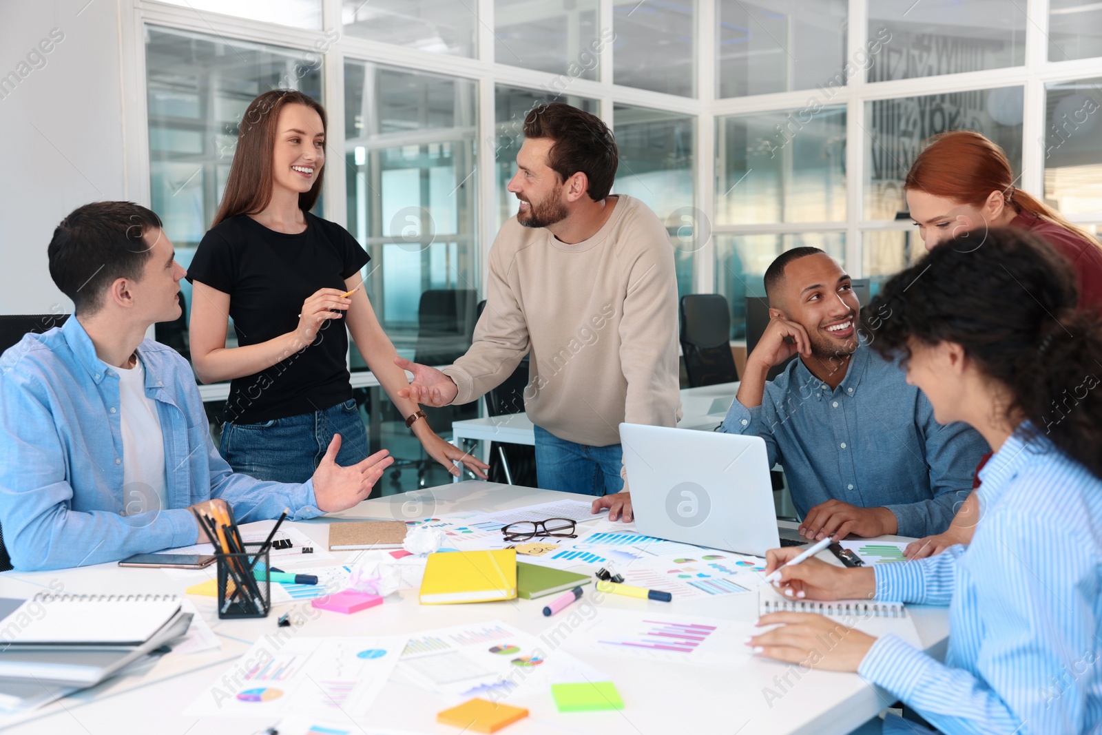 Photo of Team of employees working together at table in office. Startup project