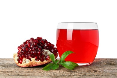 Photo of Refreshing pomegranate juice in glass, leaves and fruit on wooden table against white background