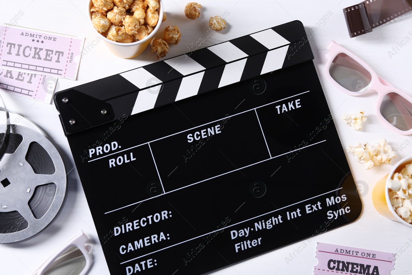 Photo of Flat lay composition with clapperboard and popcorn on white wooden table