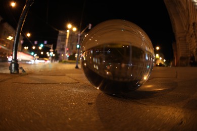 Photo of Crystal ball on asphalt road at night. Wide-angle lens