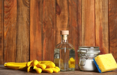 Composition with vinegar and cleaning supplies on table. Space for text