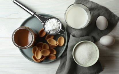 Ingredients for delicious walnut shaped cookies with condensed milk on white wooden table, flat lay