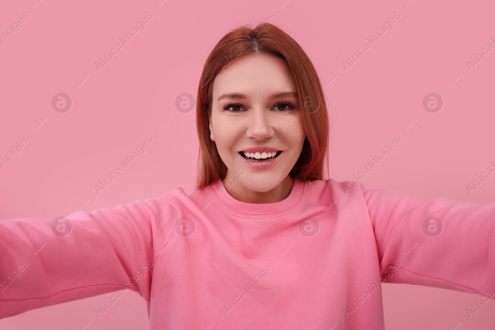 Photo of Beautiful woman taking selfie on pink background