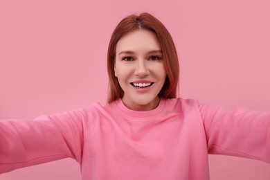 Photo of Beautiful woman taking selfie on pink background