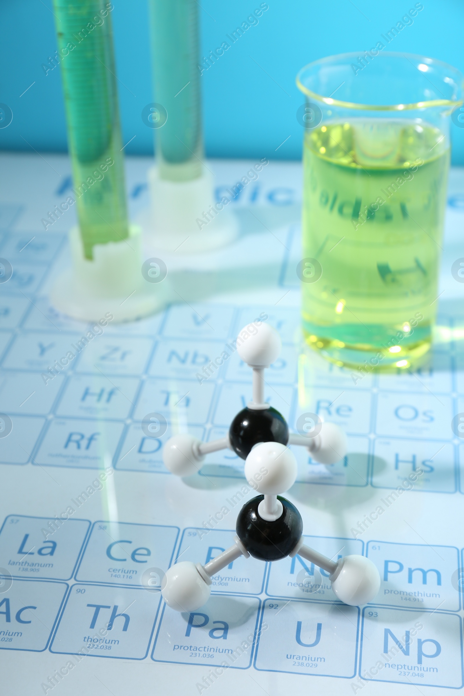 Photo of Molecular model and laboratory glassware on periodic table