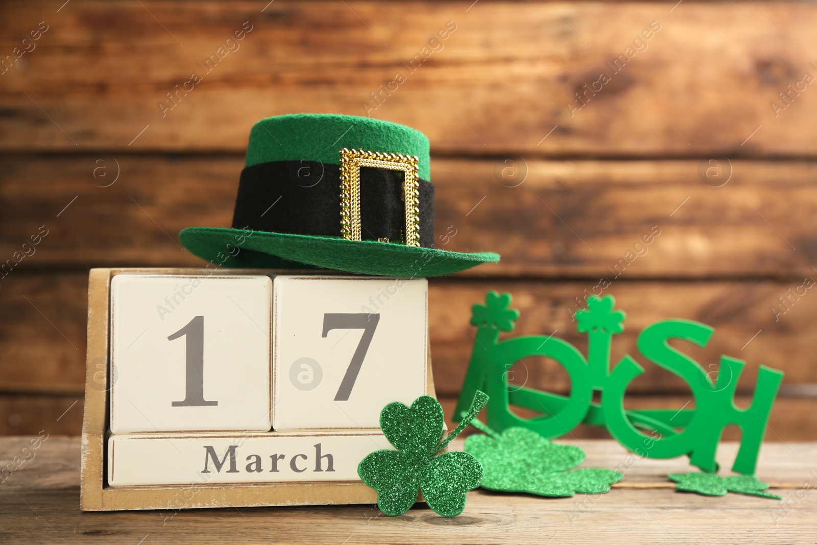 Photo of Leprechaun's hat, block calendar and St. Patrick's day decor on wooden table