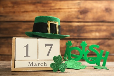 Photo of Leprechaun's hat, block calendar and St. Patrick's day decor on wooden table