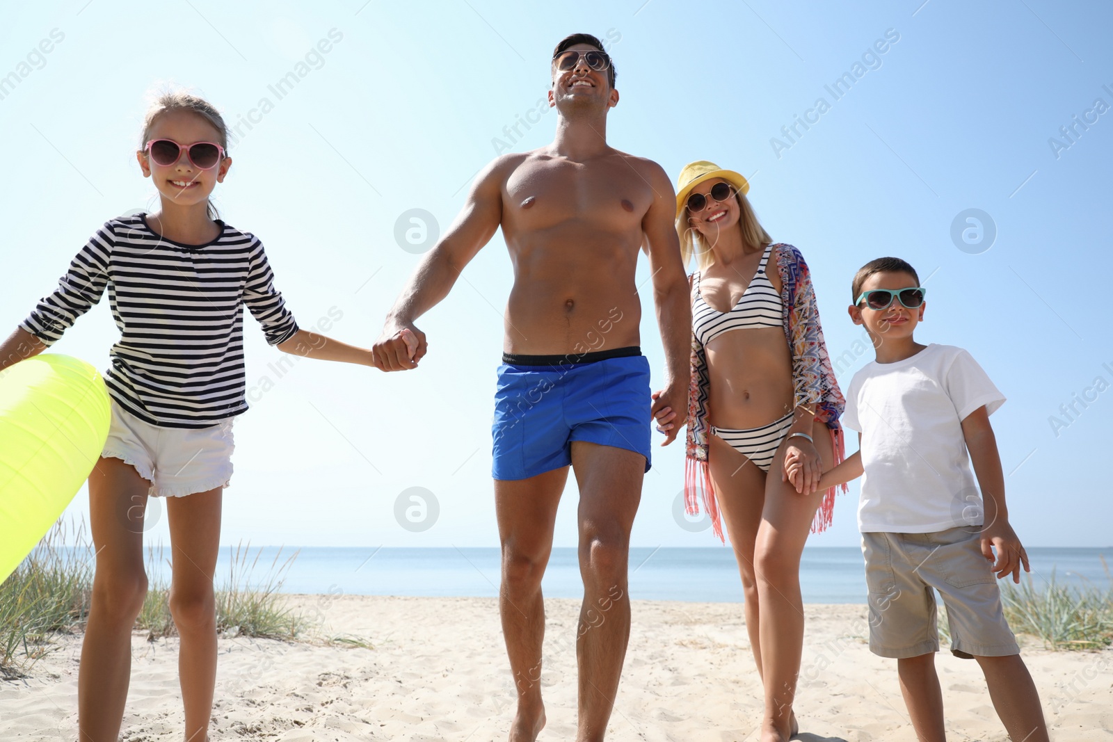 Photo of Family with inflatable ring at beach on sunny day