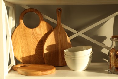 Wooden cutting boards, bowls and cookies on shelving unit