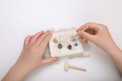 Photo of Child playing with Excavation kit on white background, above view. Educational toy for motor skills