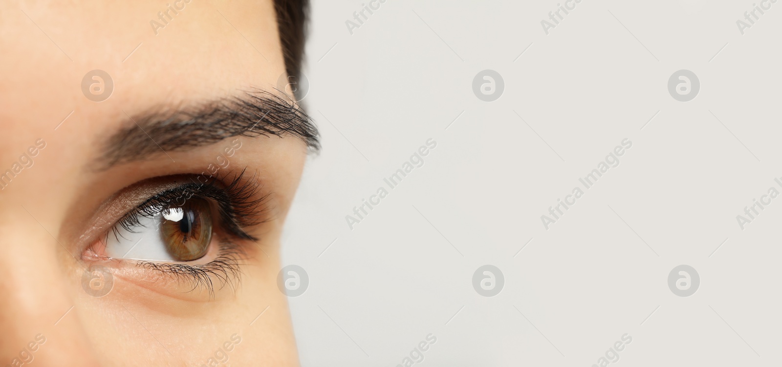 Image of Closeup view of woman with beautiful eyes on light background, space for text. Banner design