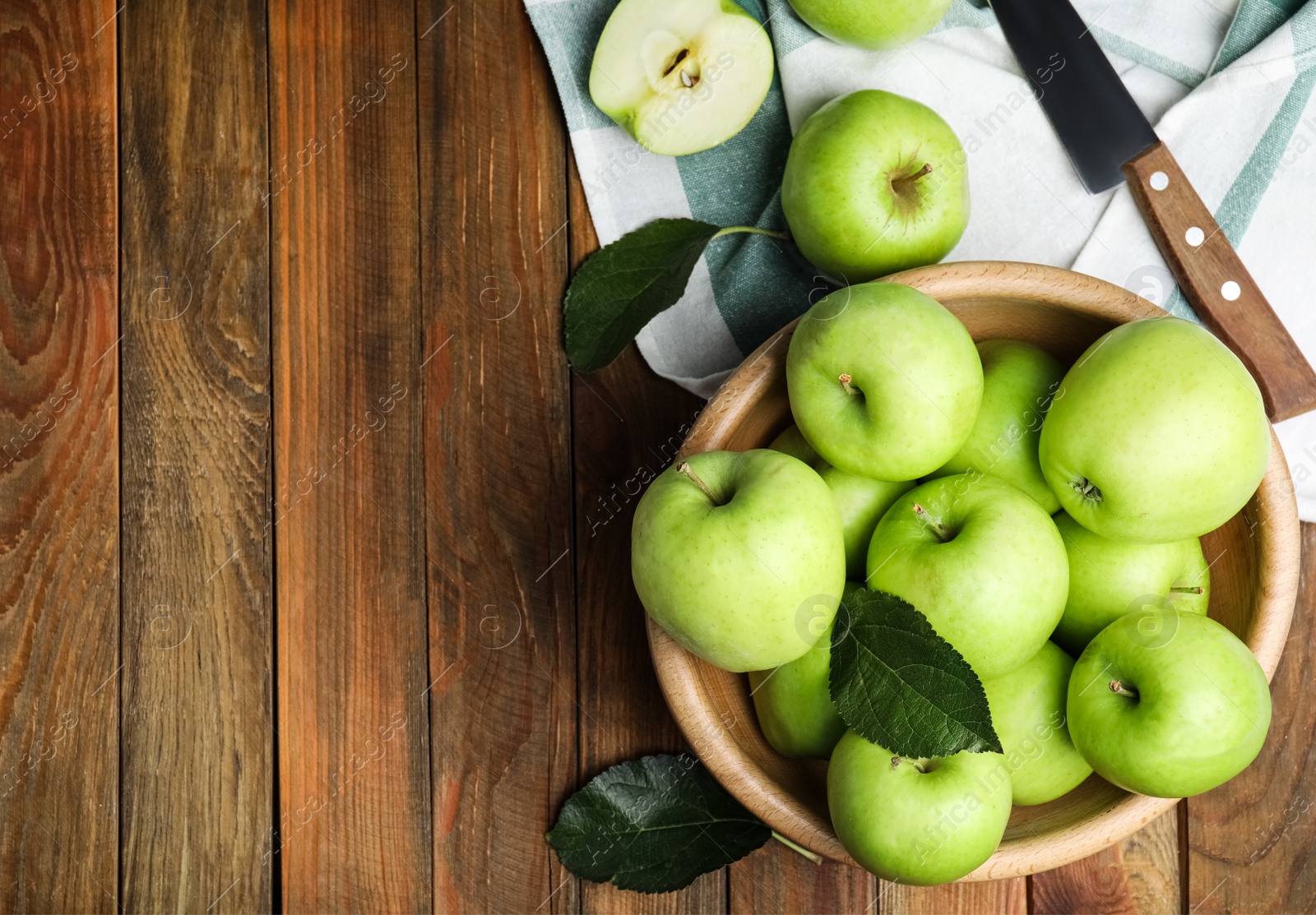 Photo of Fresh ripe green apples and knife on wooden table, flat lay. Space for text