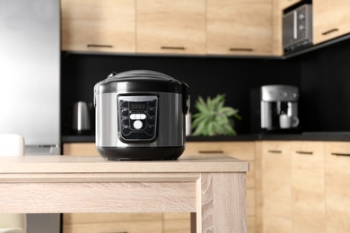 Modern multi cooker on table in kitchen, space for text