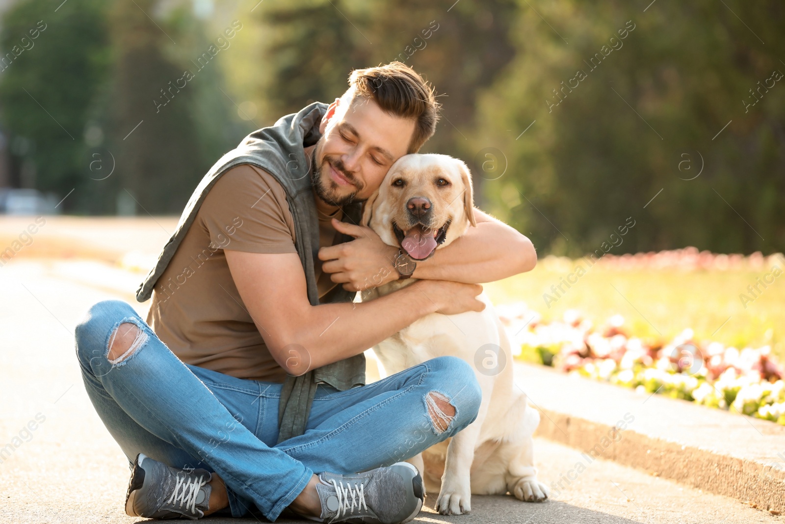 Photo of Cute yellow labrador retriever with owner outdoors