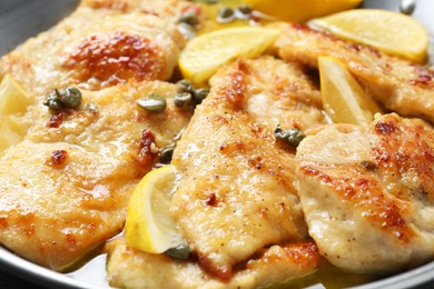 Delicious chicken piccata with lemons in pot, closeup