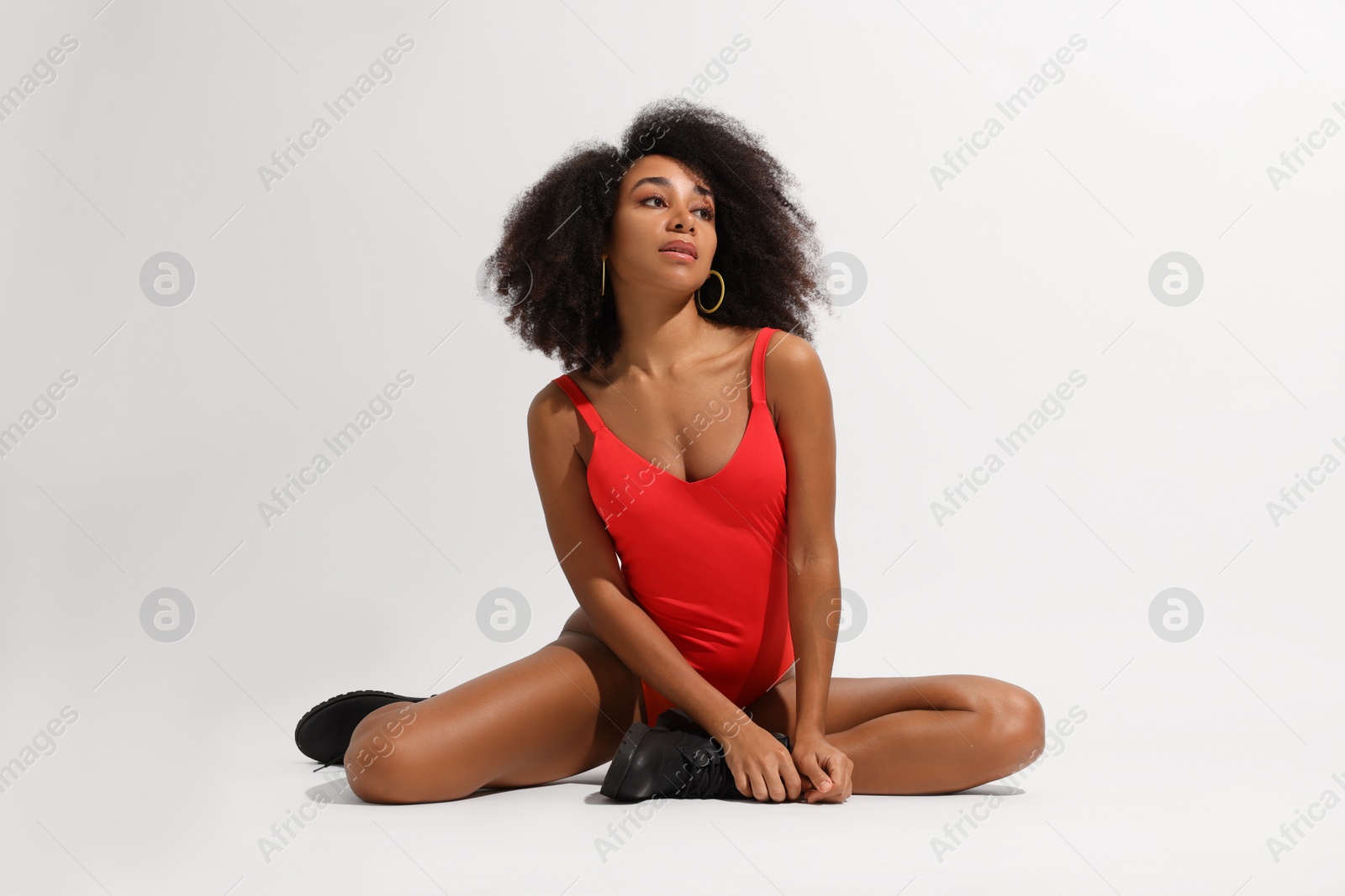 Photo of Beautiful woman in red one-piece summer swimsuit on white background