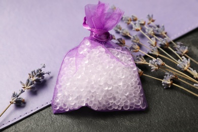 Photo of Scented sachet and dried lavender on black table, closeup